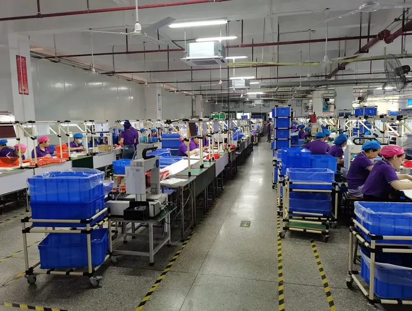 Assembly workstations, operators and a marked central aisle inside Xinyinhai’s workshop