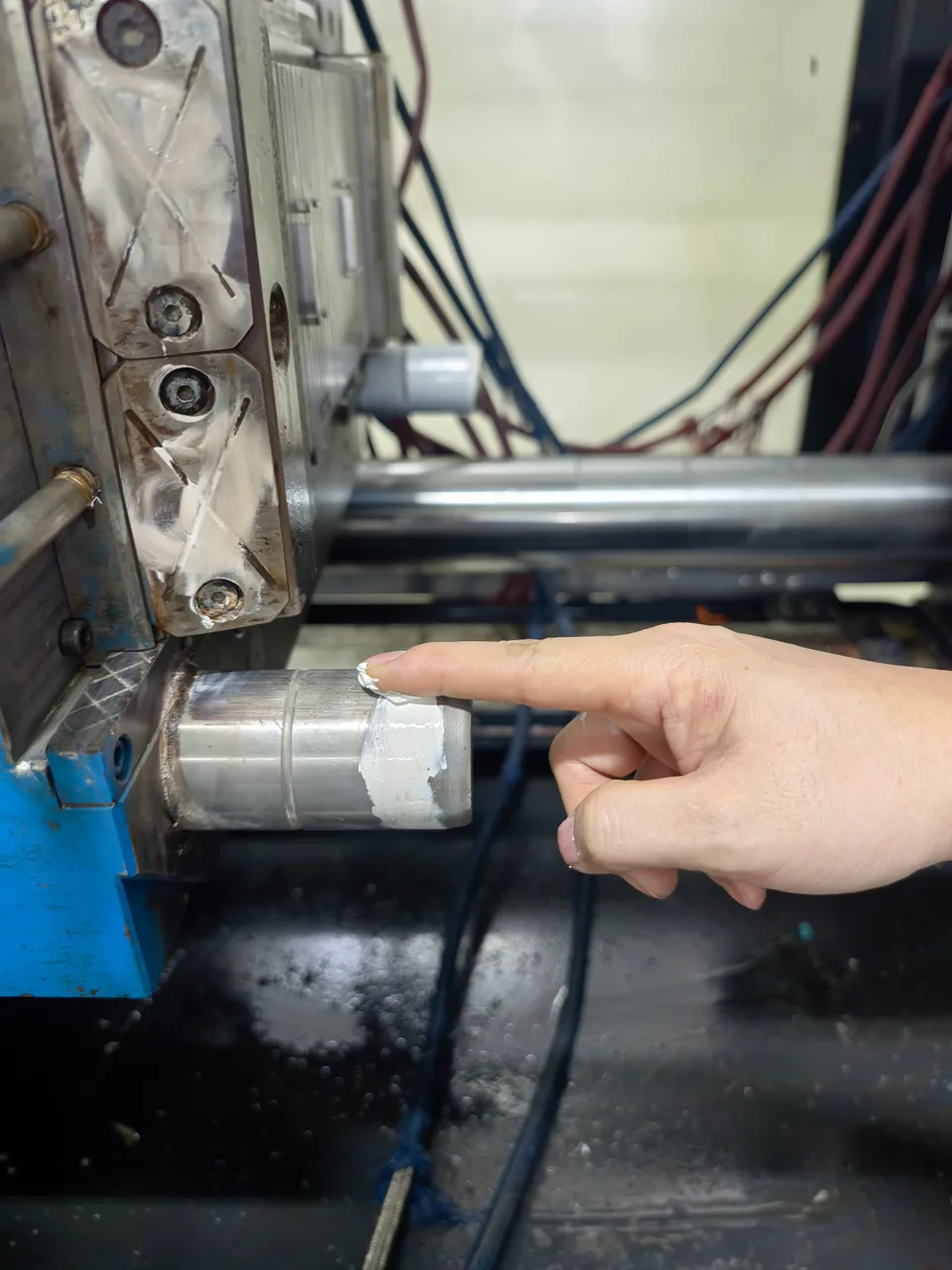 Lubricant being applied to a mold guide post during maintenance at Xinyinhai