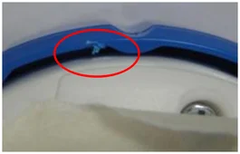 Impact damage. The ellipse marks damage to the edge of the blue molded part.