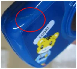 Adhesive residue. The circle identifies adhesive on the blue surface.
