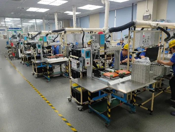 Soldering workstations arranged along an electronics workshop aisle