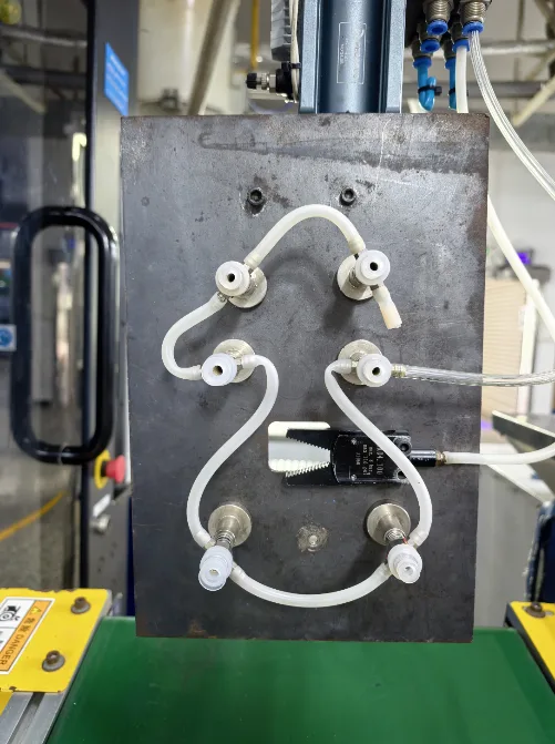 Steel-plate take-out fixture with suction cups beside a molding-machine conveyor at Xinyinhai