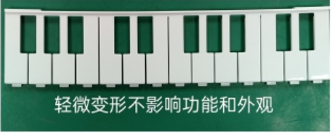 A row of molded white keys shows slight bowing, identified in the source as not affecting functionality or appearance.